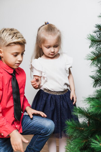 Jongen en meisje die Kerstmisboom verfraaien