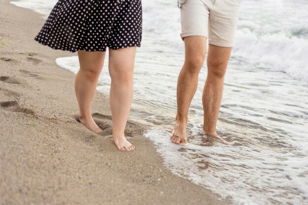 Jongen en meisje die op het strand lopen
