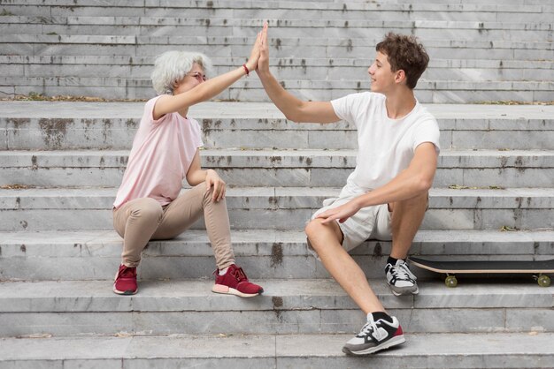 Jongen en meisje high fiving zittend op de trap