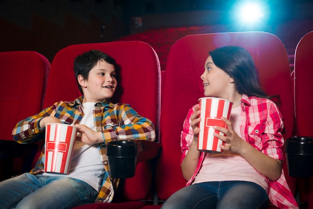 Jongen en meisje kijken naar film in de bioscoop