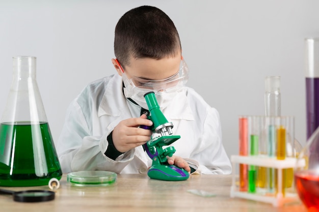 Gratis foto jongen in laboratorium met microscoop