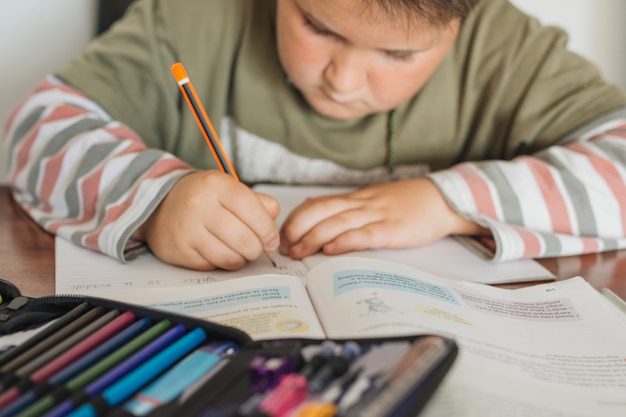 Gratis foto jongen is zijn huiswerk aan het doen