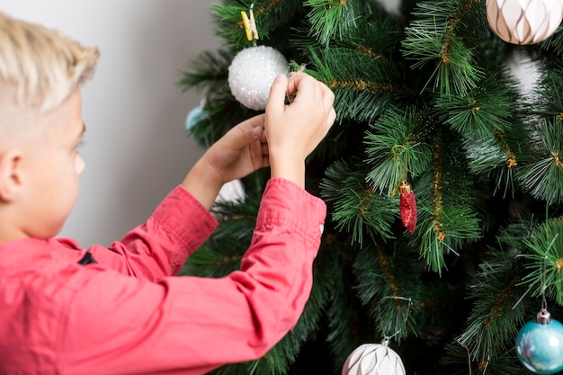 Jongen kerstboom versieren