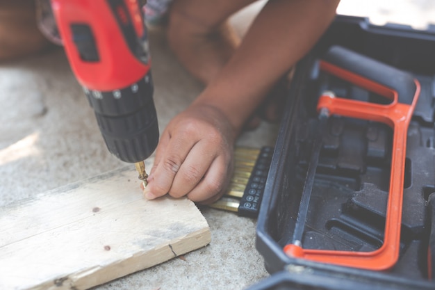 Gratis foto jongen kind houden handgereedschap elektrische schroevendraaier.