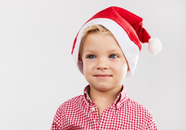 Jongen lachend met hoed van de kerstman