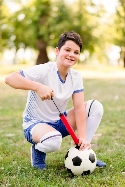 Jongen maakt zijn voetbal klaar voor een nieuwe wedstrijd