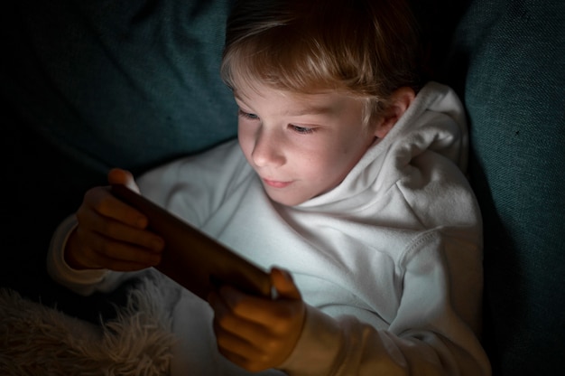 Jongen met behulp van smartphone in bed 's nachts
