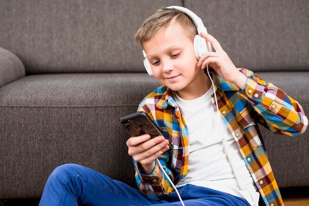Jongen met een koptelefoon met behulp van smartphone