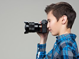 Jongen met fotocamera die foto's maakt. tienerjongen met dslr-camera fotograferen. profiel portret