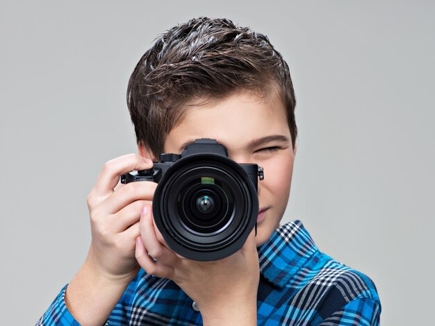 Jongen met fotocamera die foto's maakt. Tienerjongen met DSLR-camera fotograferen