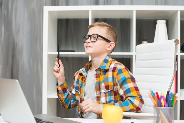 Jongen met laptop op het bureau