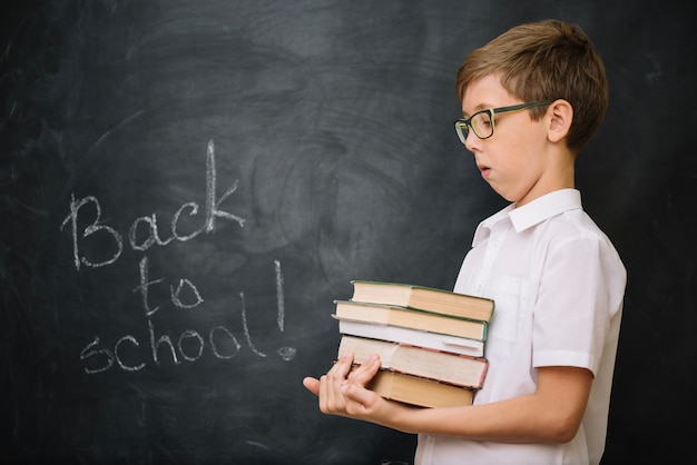 Gratis foto jongen met stapel boeken