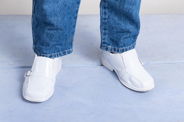 Jongen met witte schoenen die op de grond stapt