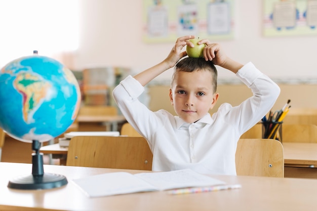 Jongen poseren met appel op les