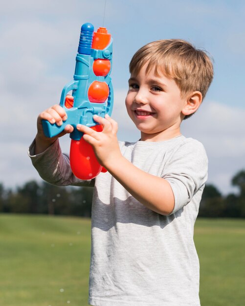 Jongen speelt met een waterpistool vooraanzicht