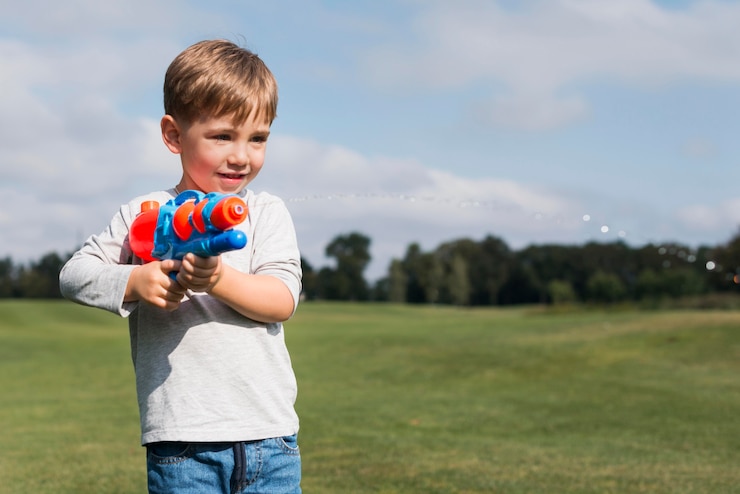 Gratis Foto jongen speelt met een waterpistool