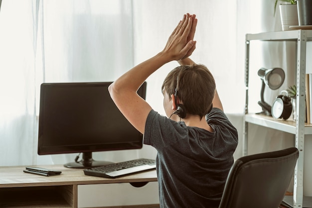 Jongen wint een online game met zijn vrienden