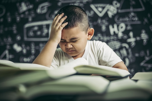 Jongens met een bril schrijven boeken en denken in de klas