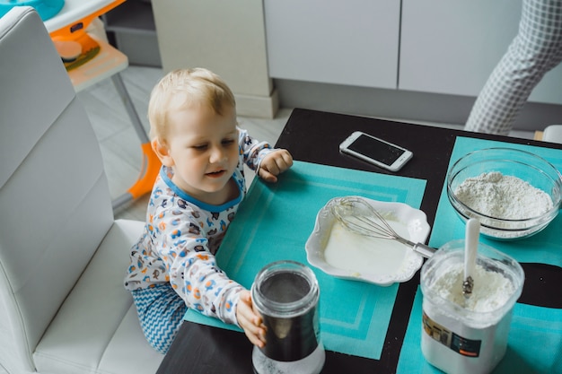 jongenskind met moeder koken in de keuken taart