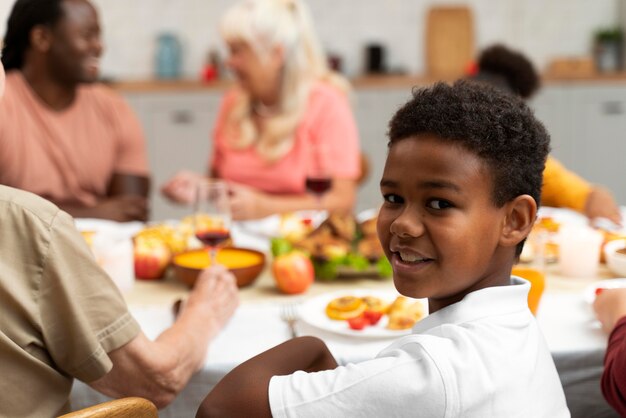 Gratis foto jongensportret naast zijn familie op thanksgiving day