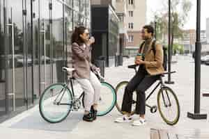 Gratis foto jongeren fietsen naar hun werk in de stad