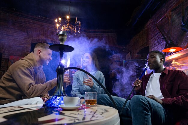 Jongeren vapen uit een waterpijp in een bar