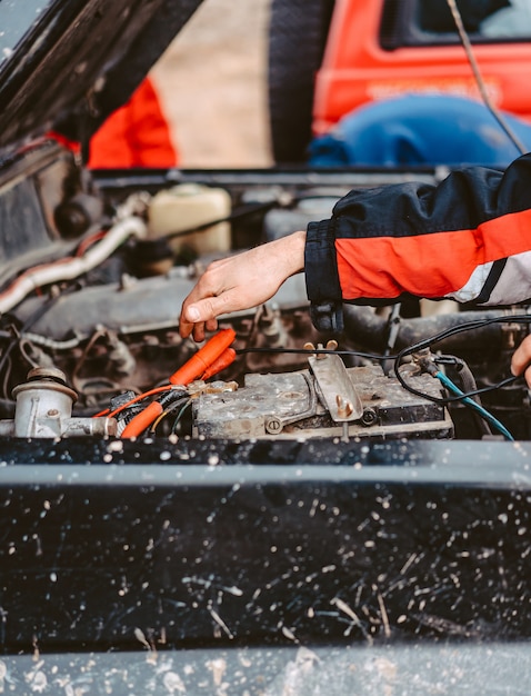 Gratis foto jump-start van de lege batterij met behulp van elektrische verbindingsdraden.