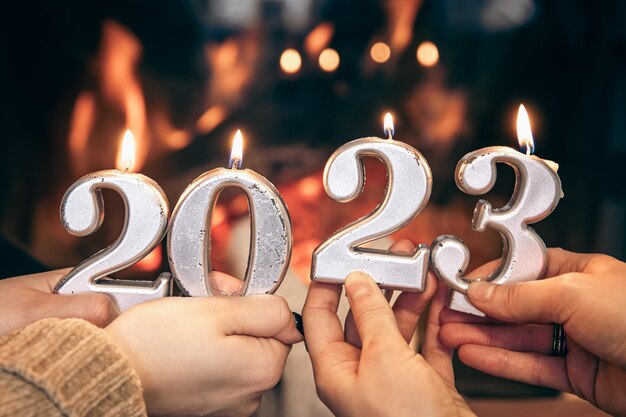 Kaarsen in de vorm van nummers 2023 in vrouwelijke handen