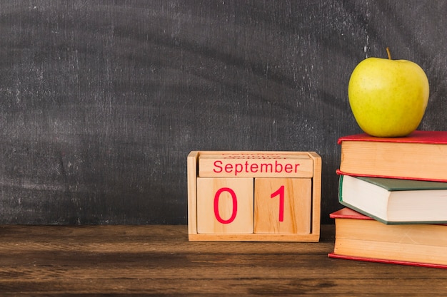 Kalender in de buurt van appel en boeken