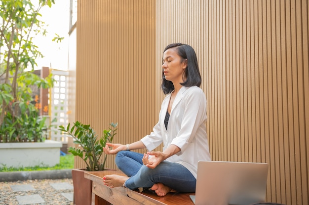 Kalme vrouw met gesloten ogen beoefenen van yoga in de lotuspositie