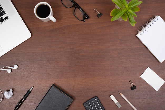 Kantoor artikelen; gadgets; kopje thee en planten met oortelefoons op een houten tafel