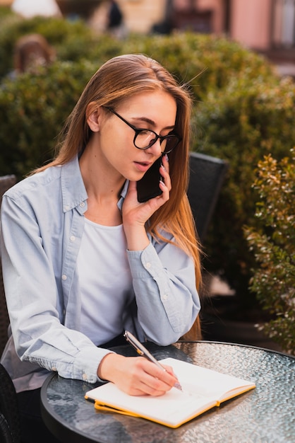 Kantoor gekleed meisje dat op telefoon spreekt