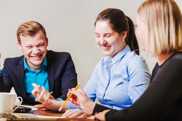 Kantoor medewerkers zitten aan de balie glimlachen