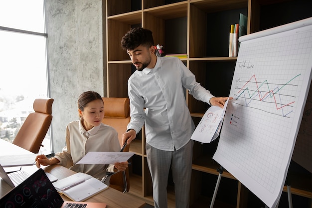 Gratis foto kantoormedewerkers die financiële grafieken gebruiken