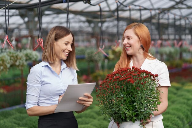 Kaseigenaar presenteert bloemenopties aan een potentiële klantendetailhandelaar.