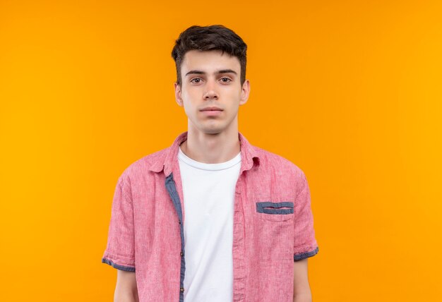 Kaukasische jonge man met roze shirt op geïsoleerde oranje muur