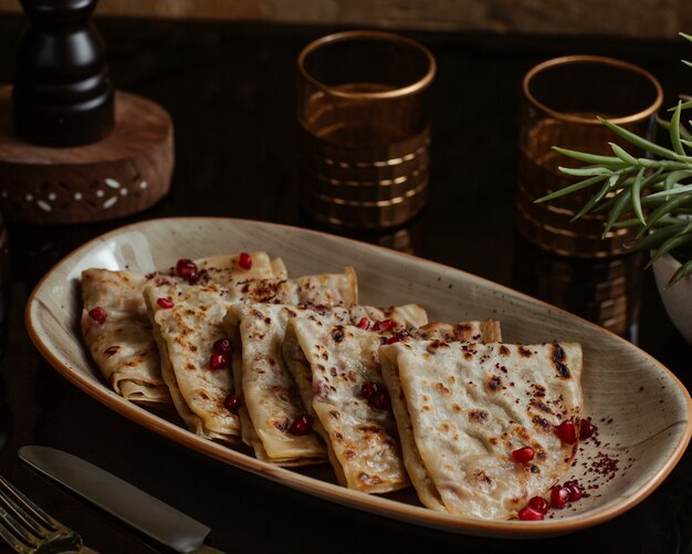 Kaukasische qutab, kutab, gozleme geserveerd met granaatappelzaden in een granieten plaat