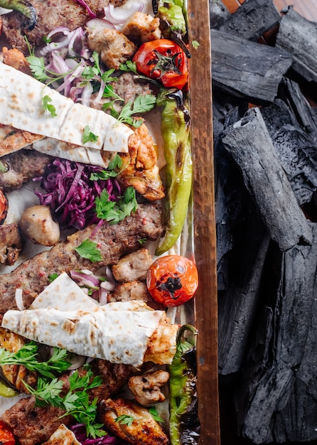 Gratis foto kaukasische traditionele kebabschotel met geroosterd voedsel en kruiden.