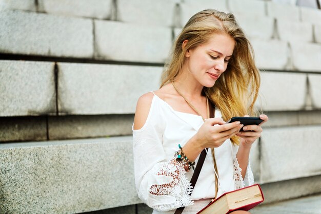 Kaukasische vrouw die mobiele telefoon in openlucht met behulp van