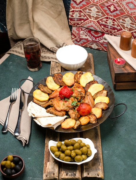 Gratis foto kaukasische zak ichi met vlees en aardappelen geserveerd met yoghurt en composto op een houten bord