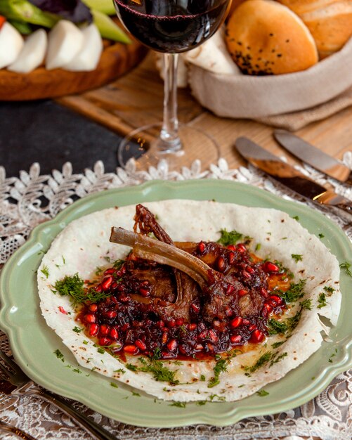 Kebab onder granaatappelsaus op de tafel