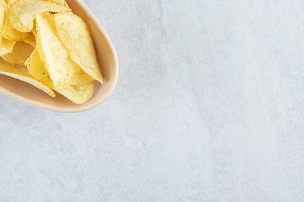 Keramische kom gezouten knapperige chips op steen.