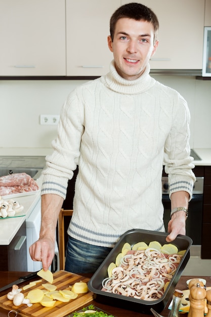 Kerel kokend vlees met aardappels