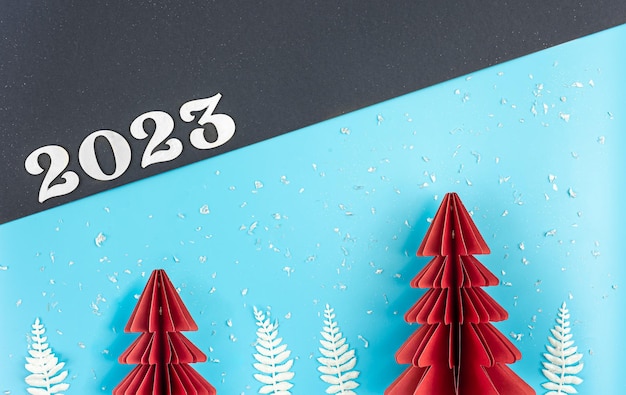 Gratis foto kerst achtergrond met origami papier boom en nummer 2023 plat leggen