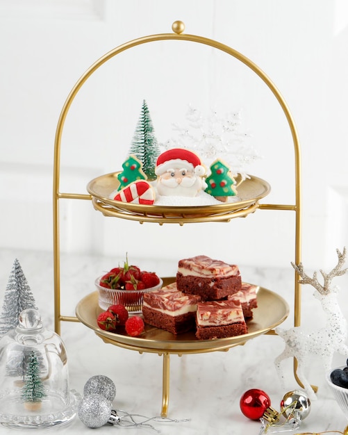 Kerst high tea dessert tafel met fruit, bessen, cake en cookies concept, witte kerst zoete tafel instelling, kopie ruimte voor tekst. geselecteerde focus. Premium Foto