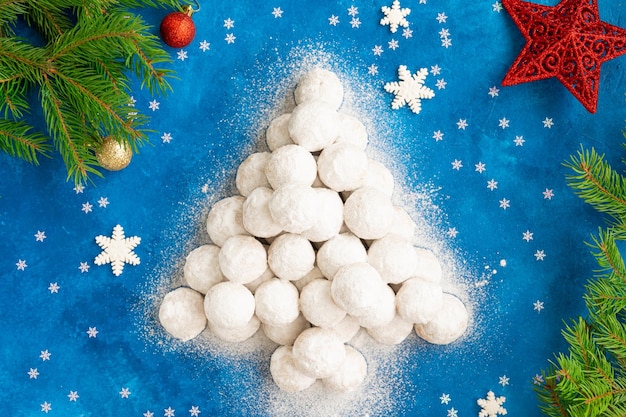 Kerst sneeuwbalkoekjes in poedersuiker gedecoreerd in de vorm van een kerstboom
