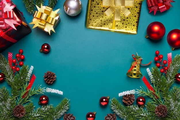 Kerstachtergrond met dennentakken, cadeau of cadeau, rode en gouden bal op donkergroene bannerachtergrond. bovenaanzicht met kopie ruimte.