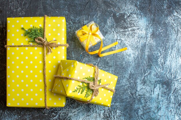 Kerstachtergrond met gele geschenkdozen en koekjes op donkere achtergrond