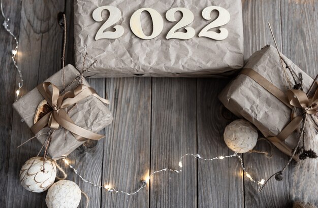 Kerstachtergrond met geschenkdozen en houtnummers 2022, plat gelegd.