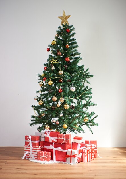 Kerstboom met rode geschenken in woonkamerdecoratie voor Gelukkig Nieuwjaar en Kerstmisconcept